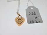 un gros plan sur un pendentif en forme de cœur en or, sur lequel est accrochée une étiquette de prix