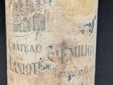 an old bottle of wine is sitting on a table