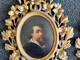 deux portraits encadrés représentant un homme et une femme, posant sur un tapis bleu