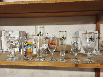 des bouteilles et des verres posés sur une étagère dans une pièce dotée d'une étagère en bois