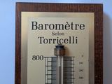 a thermometer on the wall that reads barometere selon torricellii