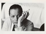 photographie en noir et blanc d'une femme tenant une cigarette à la main