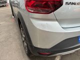 the rear end of a silver car parked in a parking lot