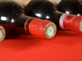 several bottles of wine are lined up on a red table