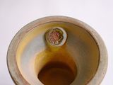 a white vase with a brown lid on a white table