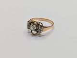 a close up of a gold and diamond ring on a white surface