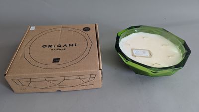a candle in a green glass bowl next to a box