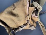 a brown bag with a brown handle hanging from it ' s side