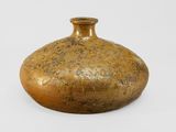 a brown vase that is sitting on a white surface