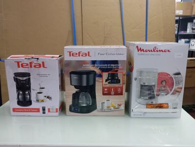three boxes of coffee machines sitting on a table