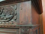 a wooden cabinet with carvings on the top of it