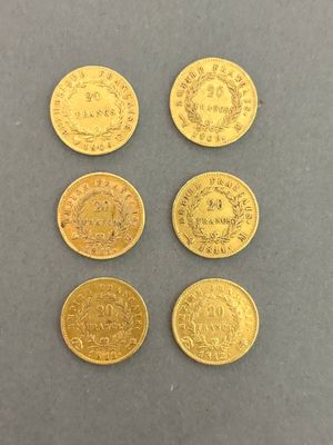four different types of gold coins on a gray surface