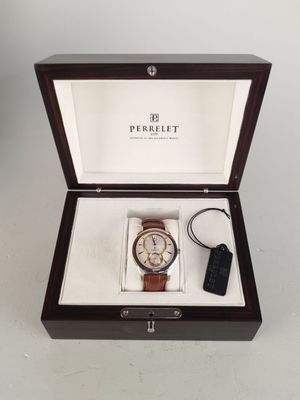 La montre est dans une boîte avec une clé et un porte-clés.