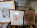 deux photos encadrées posées sur une table, à côté d'une pile de livres