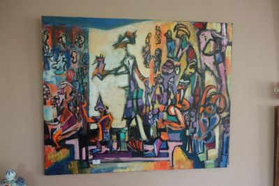 un tableau accroché au mur au-dessus d'un lit dans une chambre