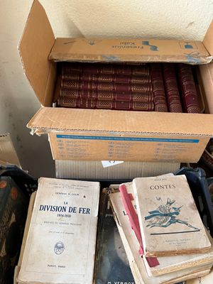 des boîtes de livres sont empilées dans une pièce