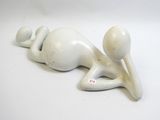 a white figurine of a person laying on the ground
