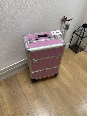 a pink suitcase sitting on the floor next to a white wall