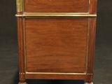 a small wooden cabinet with brass trimming on the top