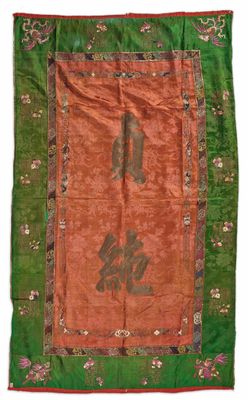 un tapis chinois orange et vert orné d'inscriptions orientales
