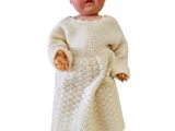 poupée vêtue d'une robe en tricot blanche et de chaussures blanches