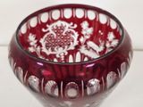 a red glass bowl with white designs on it