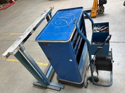 un chariot bleu chargé d'outils dans un entrepôt