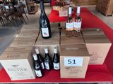 Plusieurs bouteilles de vin sont posées sur une table, à côté de cartons de vin