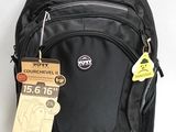 un sac à dos noir muni d'une étiquette, posé sur une surface blanche
