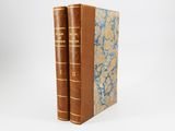 a pair of books sitting on top of each other on a white surface