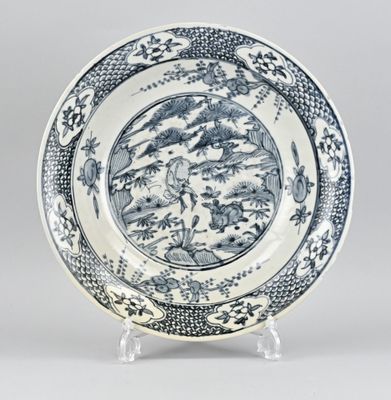 une assiette bleue et blanche ornée d'un paysage