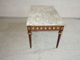 a marble top table with wooden legs in a room