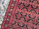 three oriental rugs on a wooden floor, one with a red and black design