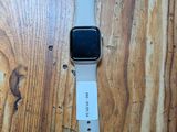 une Apple Watch blanche posée sur une table en bois