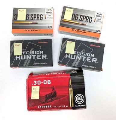 trois boîtes de munitions sont posées les unes à côté des autres sur une surface blanche