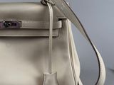 a close up of a white leather handbag on a gray surface