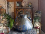 a large vase sitting on top of a table in front of a mirror