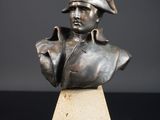 buste en bronze d'un homme coiffé d'un chapeau, posé sur un socle