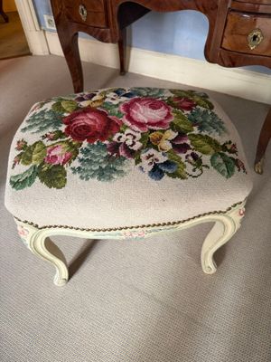an upholstered foot stool with a floral design on it