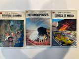 three books on a table with a shadow of a car in the background