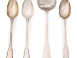 four spoons and a spoon rest on a white surface