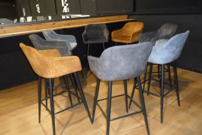 four stools that are sitting in front of a bar