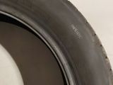 a close up of a tire on the side of a white wall