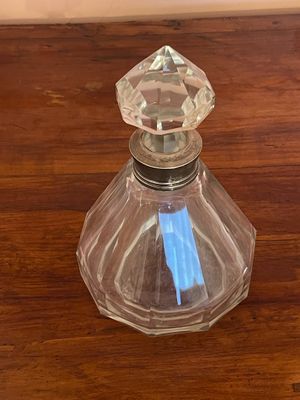 a glass bottle with a blue pen in it on a wooden table