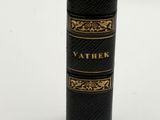 a black and gold book that is sitting on a white surface