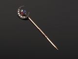 a gold, diamond and sapphire stick with a crescent on it
