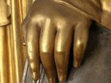 a statue of a person holding a bell with their hands