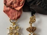 two medals and a ribbon on a white surface