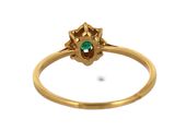 an image of a close up of a gold ring with a green stone