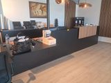 un bureau sur lequel est posé un sac, dans une pièce au sol en parquet